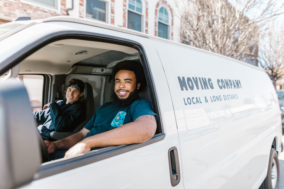 Friendly moving crew smiling while holding moving boxes