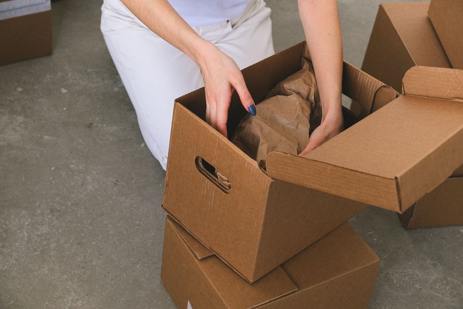 Movers carefully packing cardboard boxes in a living room